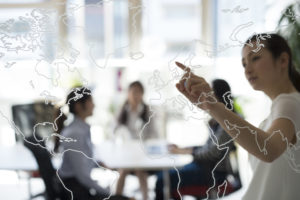 World map with women pointing at it